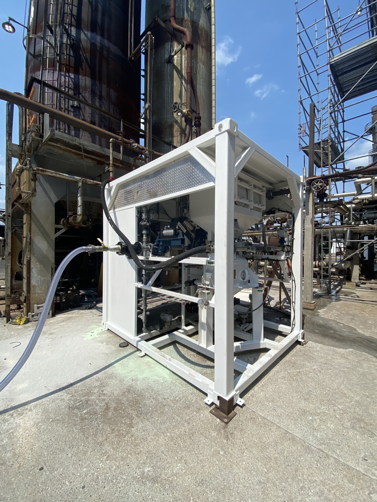Skid-mounted injection unit beside refinery process columns